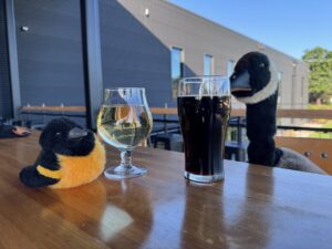Canada goose and a Baltimore oriole plushies enjoy beers at Logboat Brewing Company.